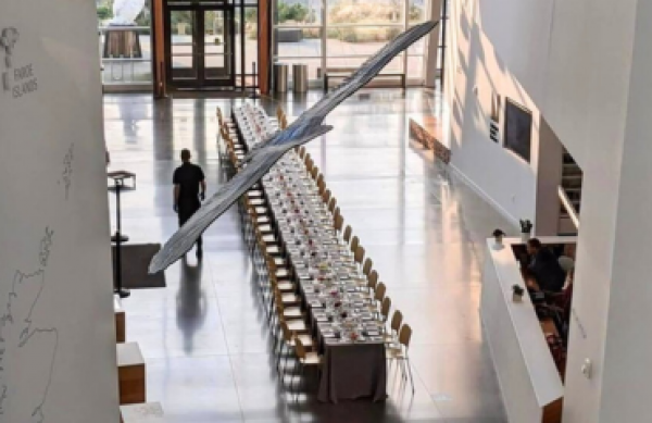 A long table is set up for dinner, running down the majestic Fjord Hall.